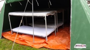 8 personen slapen op stapel bedden in onze tent.